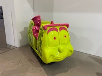 a yellow and pink train with a smiling face on it