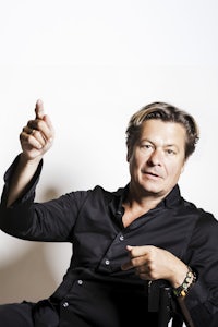 a man in a black shirt pointing his finger