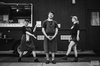 three people standing in front of a food truck