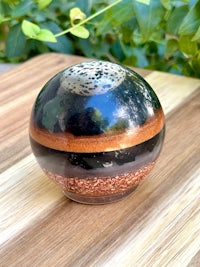 a black and brown sphere sitting on top of a wooden table