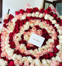 a bouquet of roses with a card on top