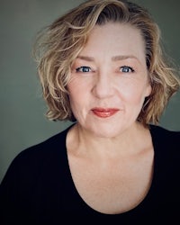 a woman in a black top is posing for a photo