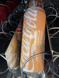 a can of coca cola sitting on a shelf