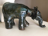 a ceramic elephant standing on top of a chair