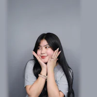 a young asian woman posing with her hands on her face