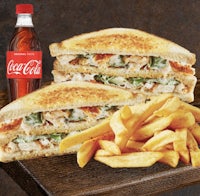 a grilled chicken sandwich with fries and coca cola