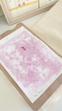 a piece of paper with a pink splatter on it