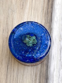 a blue and green stone on top of a wooden table