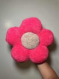 a person holding a pink flower shaped toy