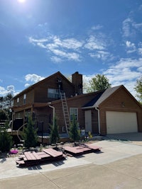 a house is being painted with a ladder in front of it