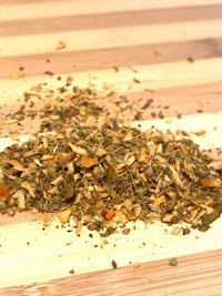 a pile of dried herbs on a wooden table