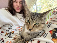 a girl laying on a blanket with a cat