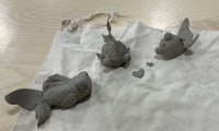 three clay fish on a piece of cloth