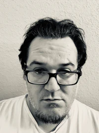 a black and white photo of a man with glasses