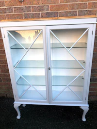 a white display cabinet with glass doors