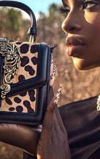 a woman holding a leopard print handbag