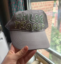 a person holding a hat that says chloe toast