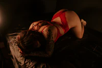 a woman in red lingerie laying on a bed