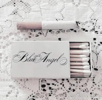 a box of matches and a cigarette on a doily