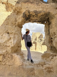 a man standing in a hole in a rock wall