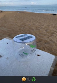 a plastic container on the beach with a smiley face on it