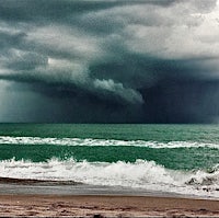 a stormy sky over a beach with waves