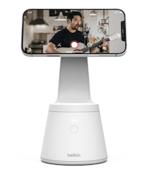 a man is playing a guitar on a stand
