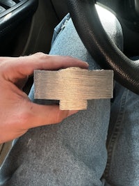 a person holding a piece of metal in a car