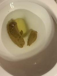 a toilet with a piece of bread in it