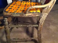 an old chair with orange flowers on it