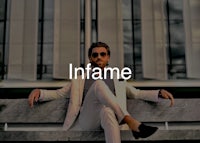 a man in a white suit sitting on a bench