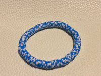 a blue and white braided bracelet on a white surface