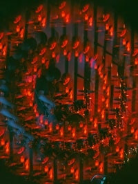 a photo of a drum set with red lights in the background