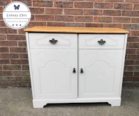 a white sideboard with two drawers and a wooden top