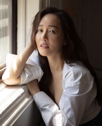 a woman leaning against a window sill