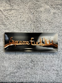 a black and brown ashtray with the word'samuel' written on it