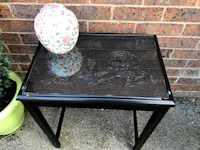 a black side table with a vase on it