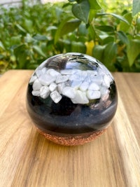 a black and white glass sphere sitting on a wooden table