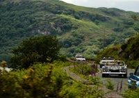 a group of cars driving down a mountain road