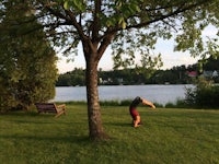 a person standing in a grassy area near a lake