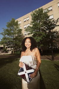 a woman in a white dress standing in front of a building