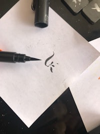 a calligraphy pen is being used to write a calligraphy letter