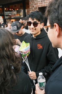 a group of people standing near a man holding a bouquet of flowers