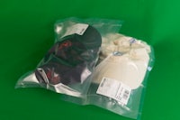 two hats in a plastic bag on a green background