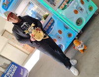 a man standing in front of a machine with a stuffed animal