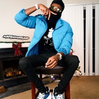 a man in a blue jacket sitting on a chair