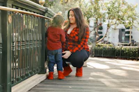 a woman and a child standing on a railing