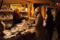 a group of people standing in front of a food stall