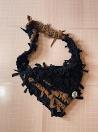 a black and brown crocheted bandana on a table