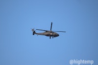 a helicopter flying through a clear blue sky